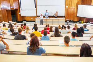 Professors and assistants explaining a lecture to a group of college students.